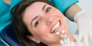 a woman is getting dental veneers and a dentist is making the teeth prepped for veneers